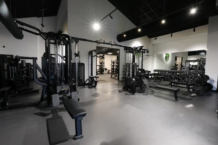 Breed overzicht van kabelstations en krachtapparatuur in de trainingszaal van Vital-GO.